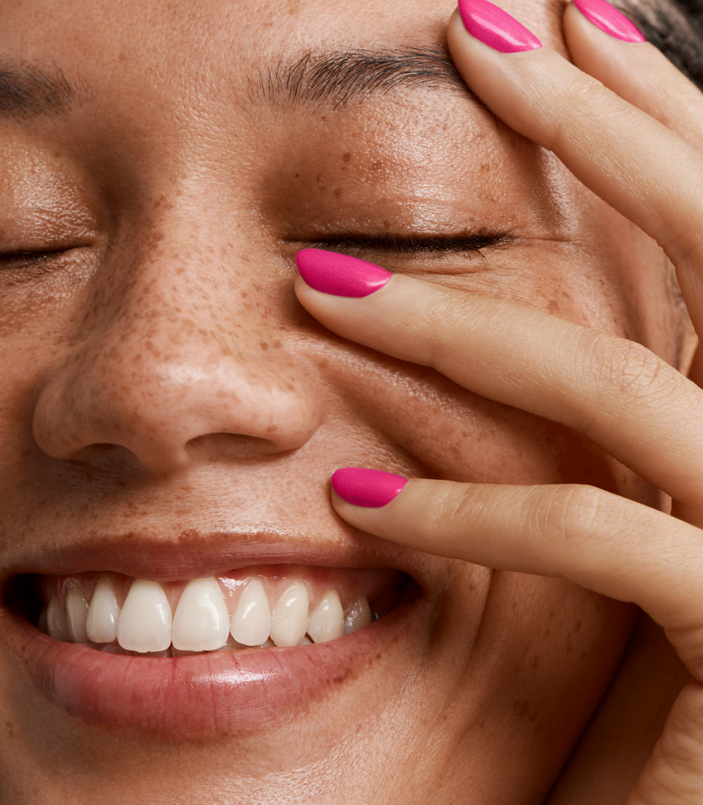 Close-up of a woman with Pink Gellac 376 Plumberry Pink manicured nails near her face.