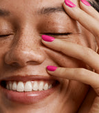 Close-up of a woman with Pink Gellac 376 Plumberry Pink manicured nails near her face.