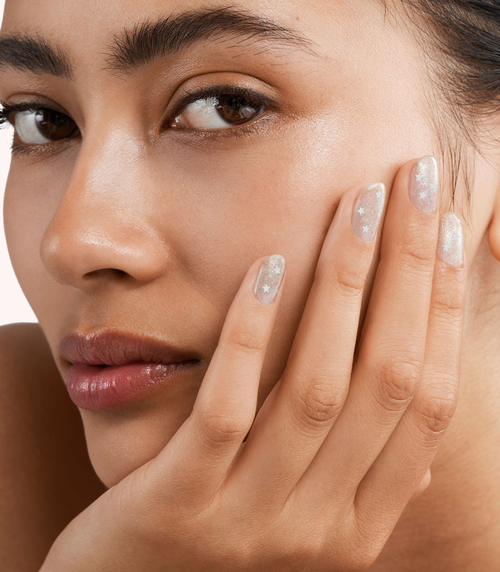 Close-up of a woman with Pink Gellac 382 Shining Star manicured nails near her face.