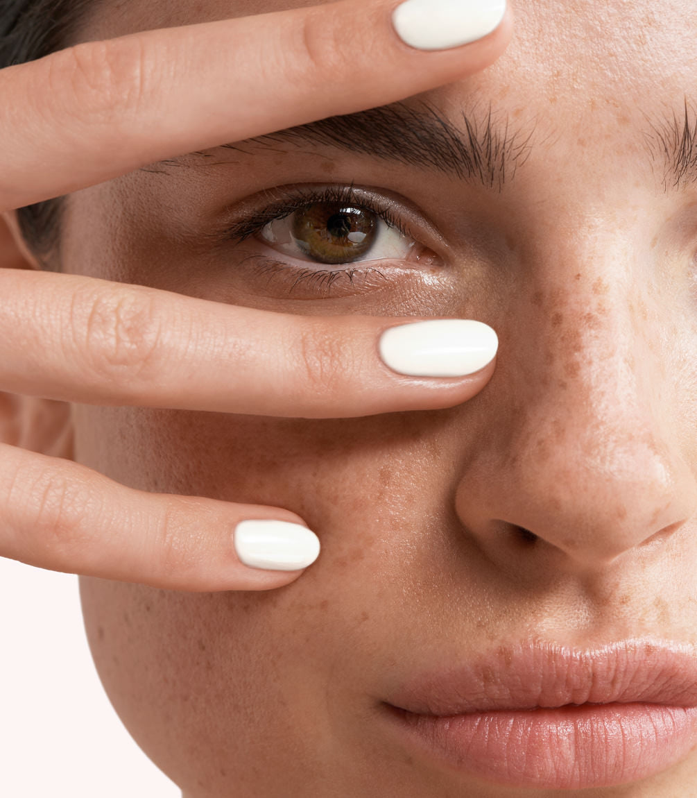 Close-up of a woman with Pink Gellac 383 Icy White manicured nails near her face.