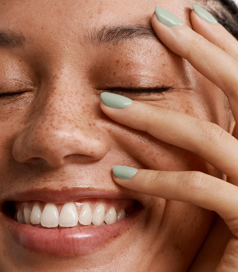 Close-up of a woman with Pink Gellac 391 Soft Sage manicured nails near her face.
