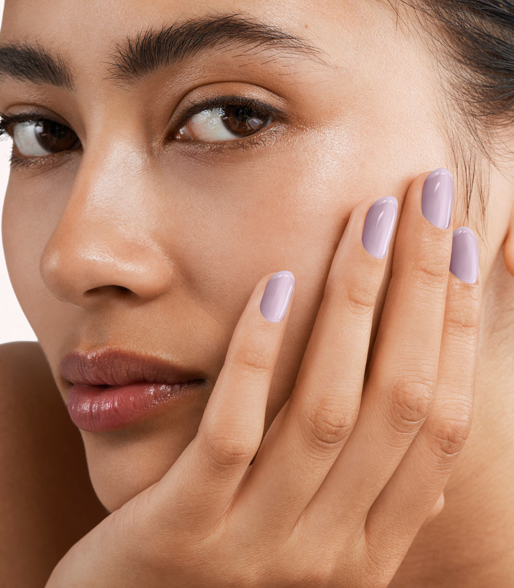 Close-up of a woman with Pink Gellac 392 Misty Lilac manicured nails near her face.