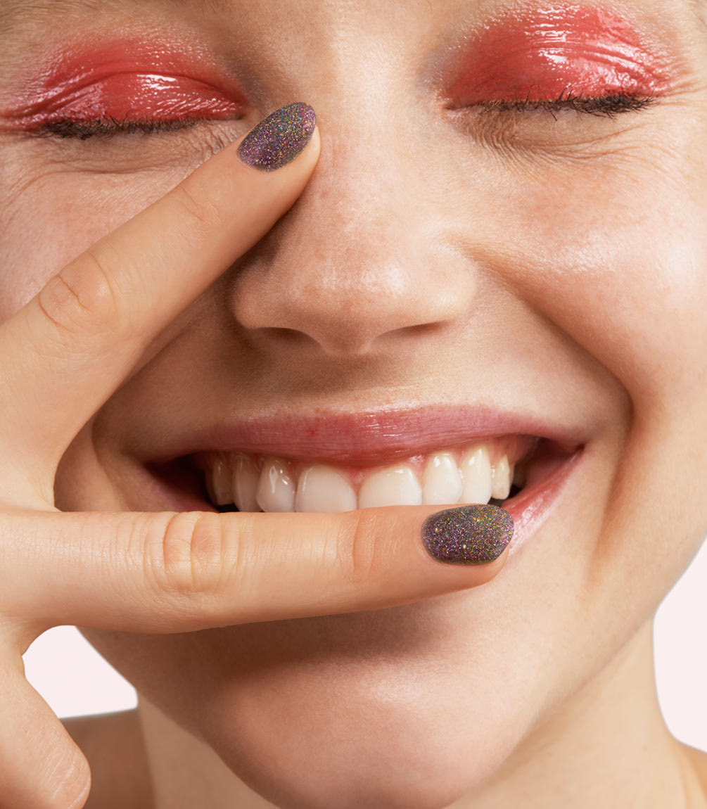 Close-up of a woman with Pink Gellac 393 Galactic Amethyst manicured nails near her face.