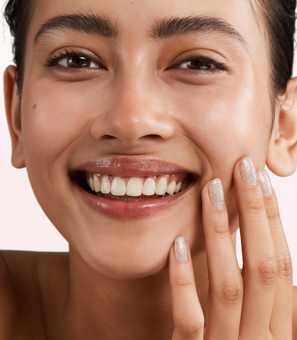 Close-up of a woman with Pink Gellac 396 Pastel Petals manicured nails near her face.