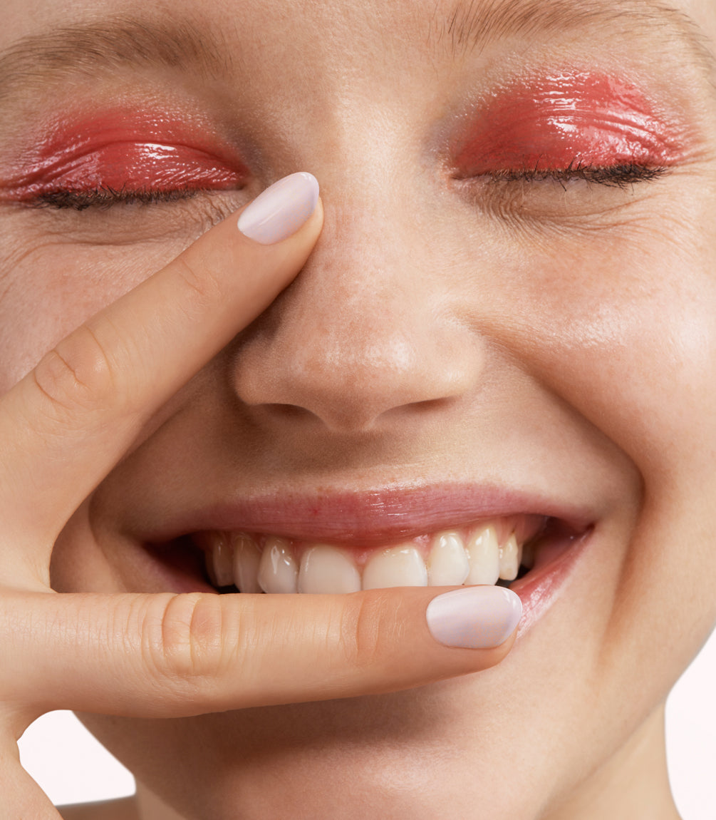 Close-up of a woman with Pink Gellac 398 Sakura Pink manicured nails near her face.