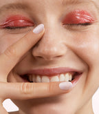 Close-up of a woman with Pink Gellac 398 Sakura Pink manicured nails near her face.