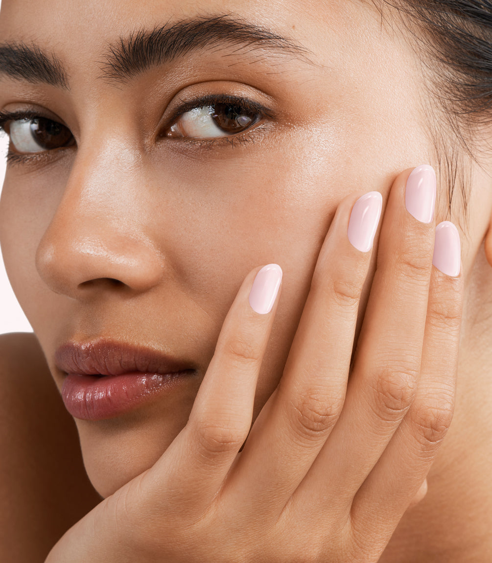 Close-up of a woman with Pink Gellac 398 Sakura Pink manicured nails near her face.