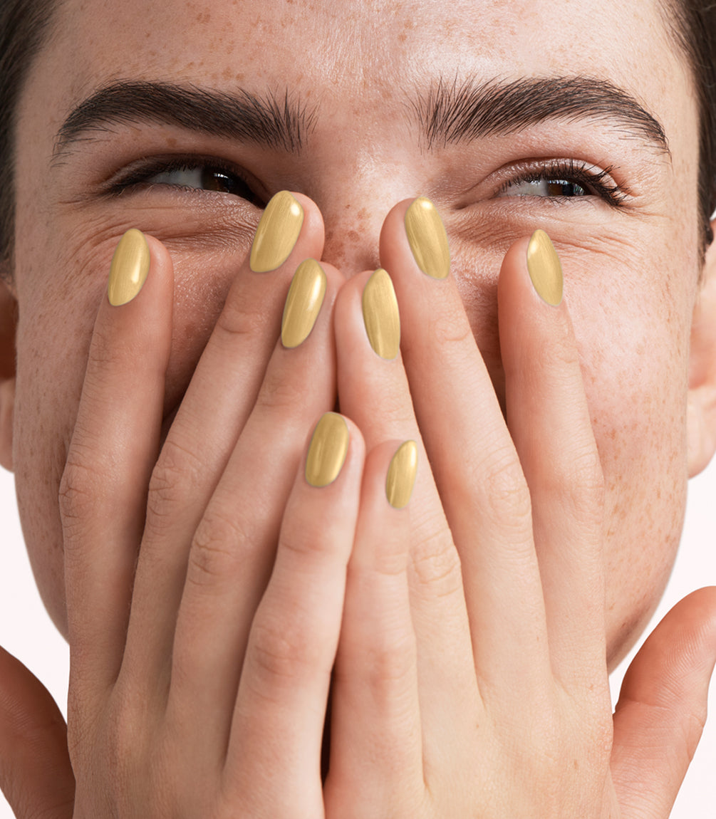 Close-up of a woman with Pink Gellac 400 Seashell Gold manicured nails near her face.