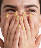 Close-up of a woman with Pink Gellac 400 Seashell Gold manicured nails near her face.