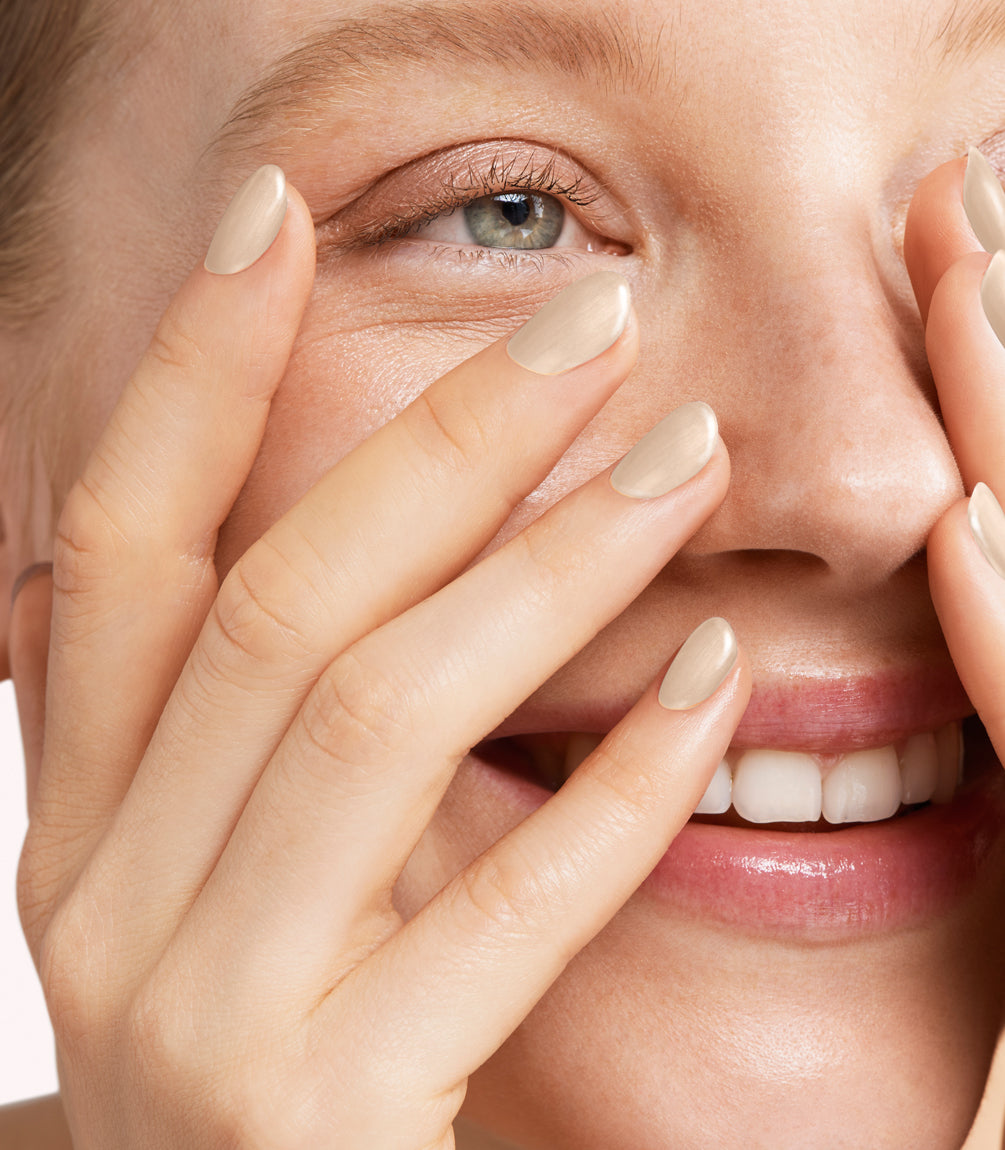 Close-up of a woman with Pink Gellac 401 Marzipan Beige manicured nails near her face.