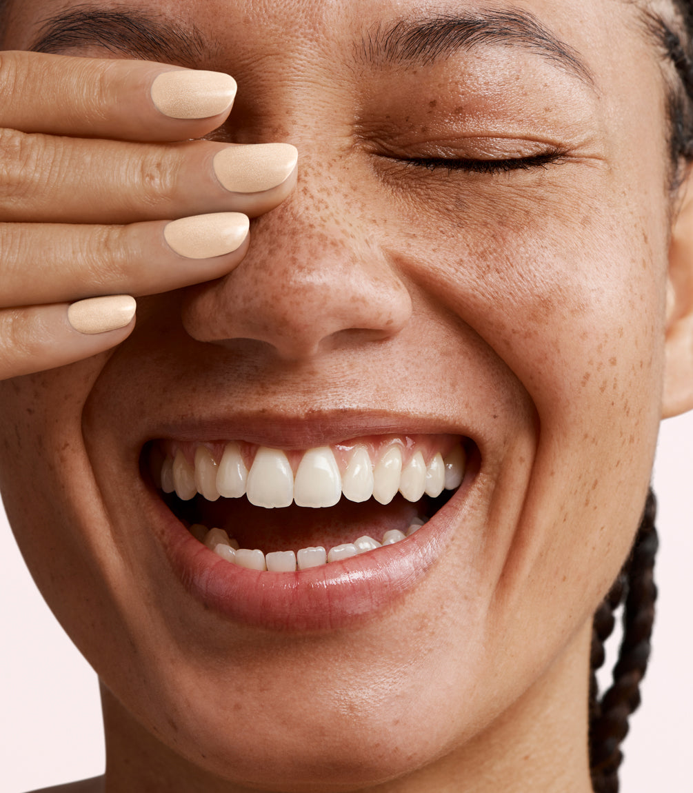 Close-up of a woman with Pink Gellac 401 Marzipan Beige manicured nails near her face.