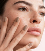Close-up of a woman with Pink Gellac 402 Light Cocoa manicured nails near her face.