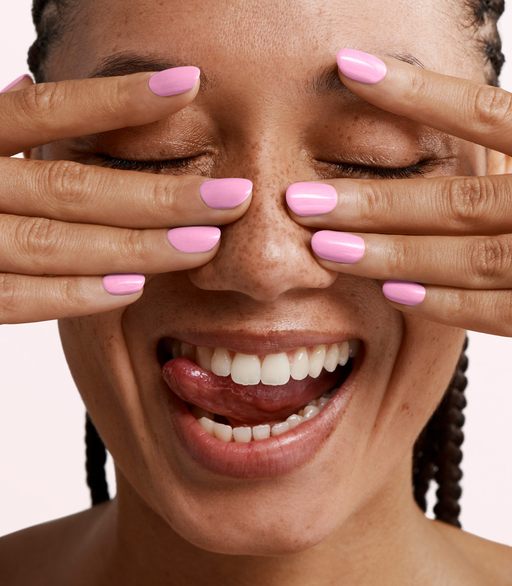 Close-up of a woman with Pink Gellac 403 Pinky Promise manicured nails near her face.