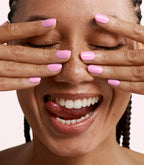 Close-up of a woman with Pink Gellac 403 Pinky Promise manicured nails near her face.