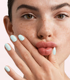 Close-up of a woman with Pink Gellac 404 Minty Moments manicured nails near her face.
