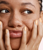 Close-up of a woman with Pink Gellac 408 Sorbet Peach manicured nails near her face.