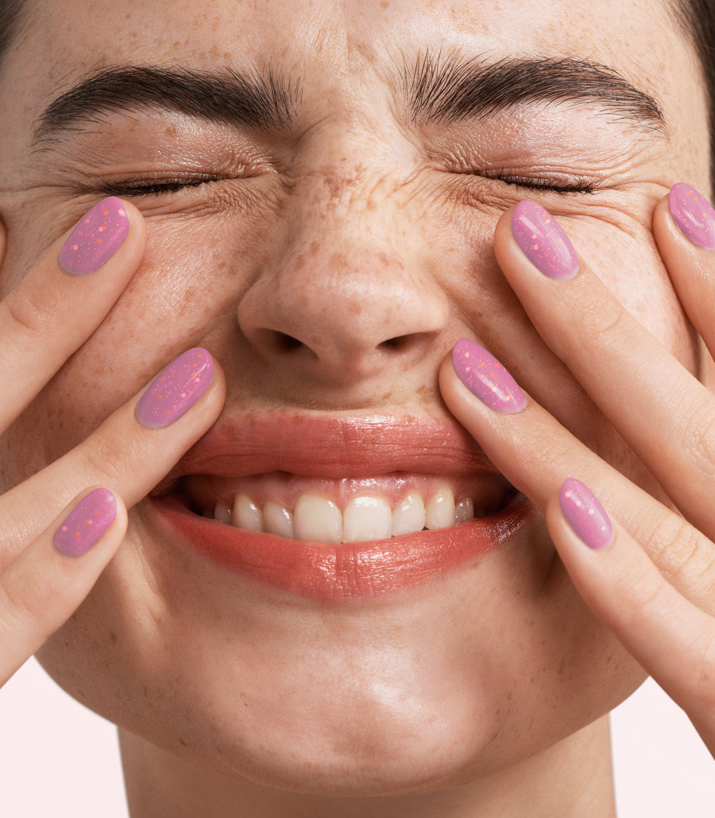 Close-up of a woman with Pink Gellac 411 Dreamy Lavender manicured nails near her face.
