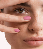 Close-up of a woman with Pink Gellac 412 Bohemian Blush manicured nails near her face.