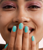 Close-up of a woman with Pink Gellac 414 Sparkling Sea manicured nails near her face.