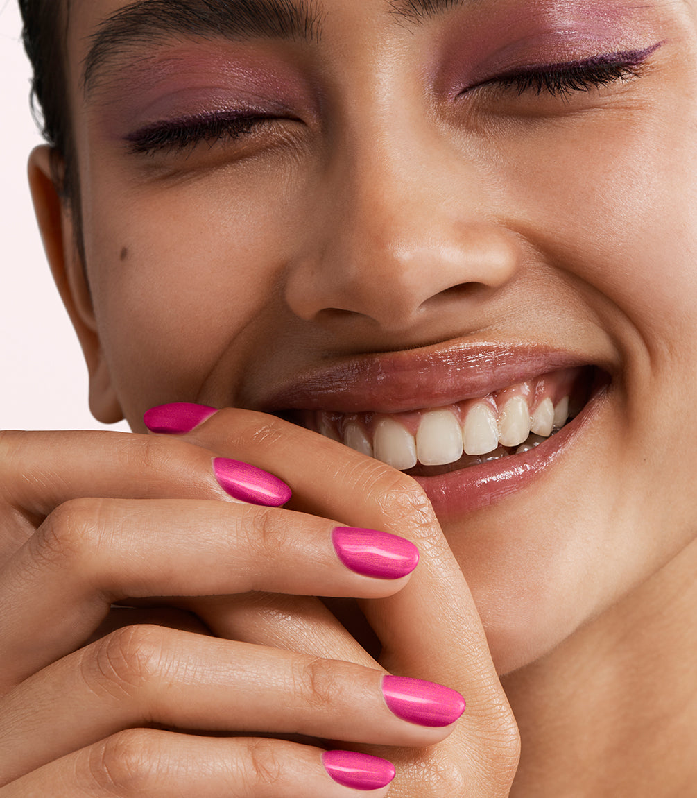 Close-up of a woman with Pink Gellac 435 Premium Pink manicured nails near her face.