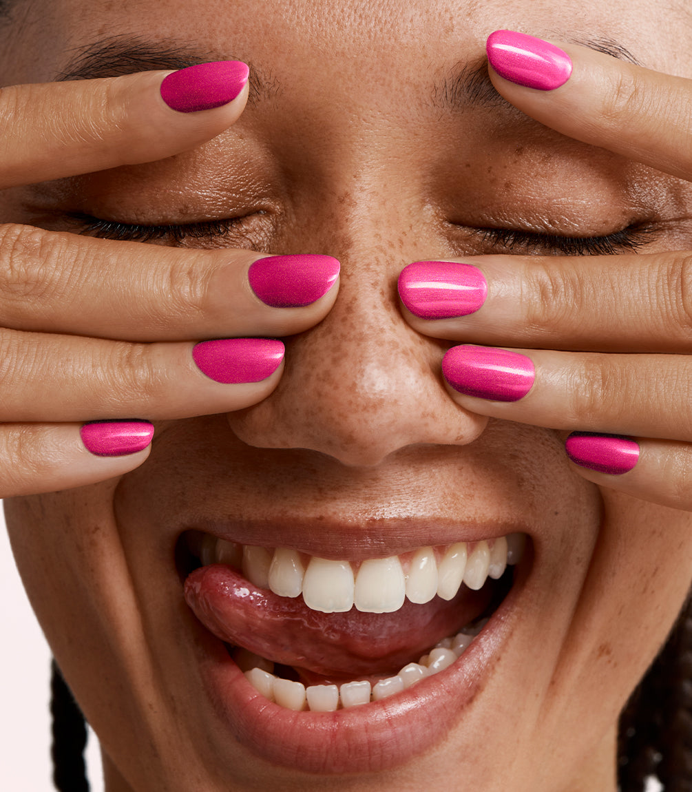 Close-up of a woman with Pink Gellac 435 Premium Pink manicured nails near her face.