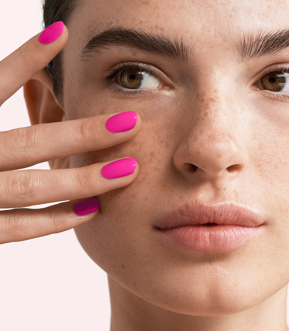 Close-up of a woman with Pink Gellac 436 Heroic Pink manicured nails near her face.