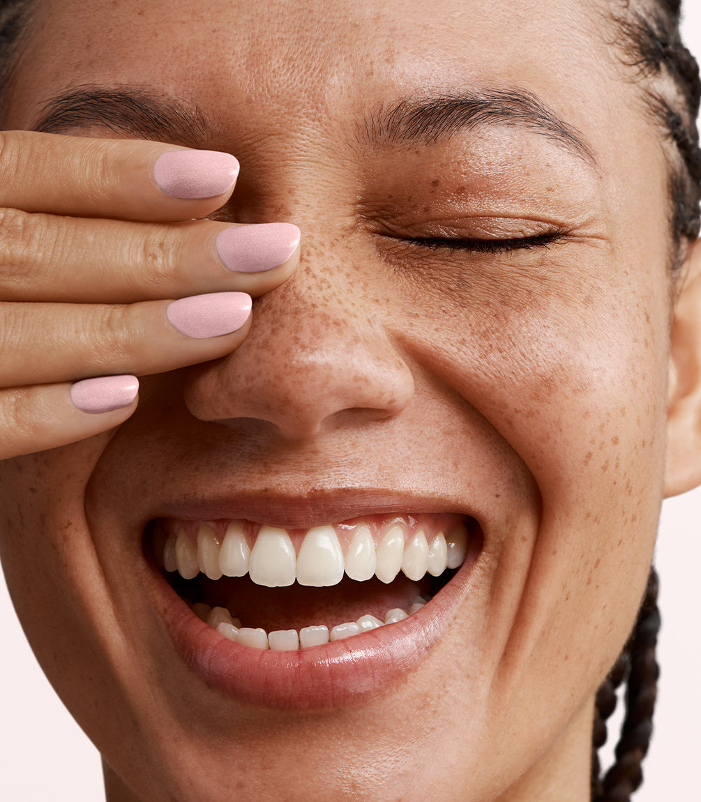 Close-up of a woman with Pink Gellac 442 Aurora Pink manicured nails near her face.