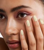 Close-up of a woman with Pink Gellac 447 Champagne Silk manicured nails near her face.