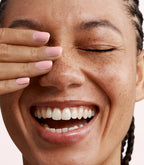 Close-up of a woman with Pink Gellac 448 Blushed Tulle manicured nails near her face.