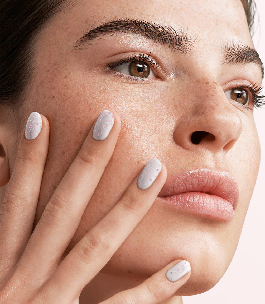 Close-up of a woman with Pink Gellac 449 Pink Petal manicured nails near her face.