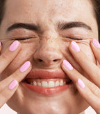 Close-up of a woman with Pink Gellac 452 Luminous Pink manicured nails near her face.