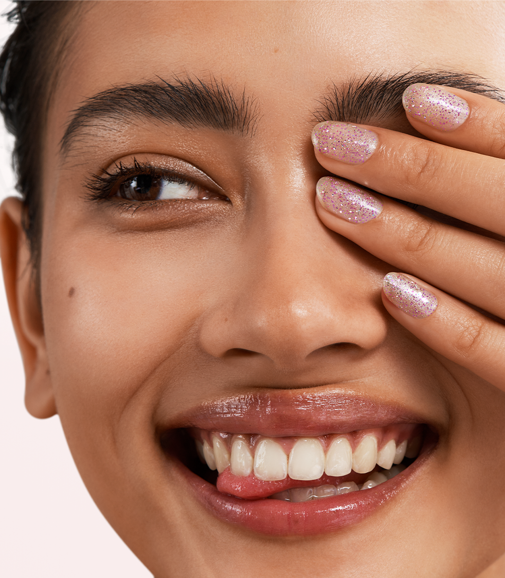 Close-up of a woman with Pink Gellac 453 Blooming Bliss manicured nails near her face.