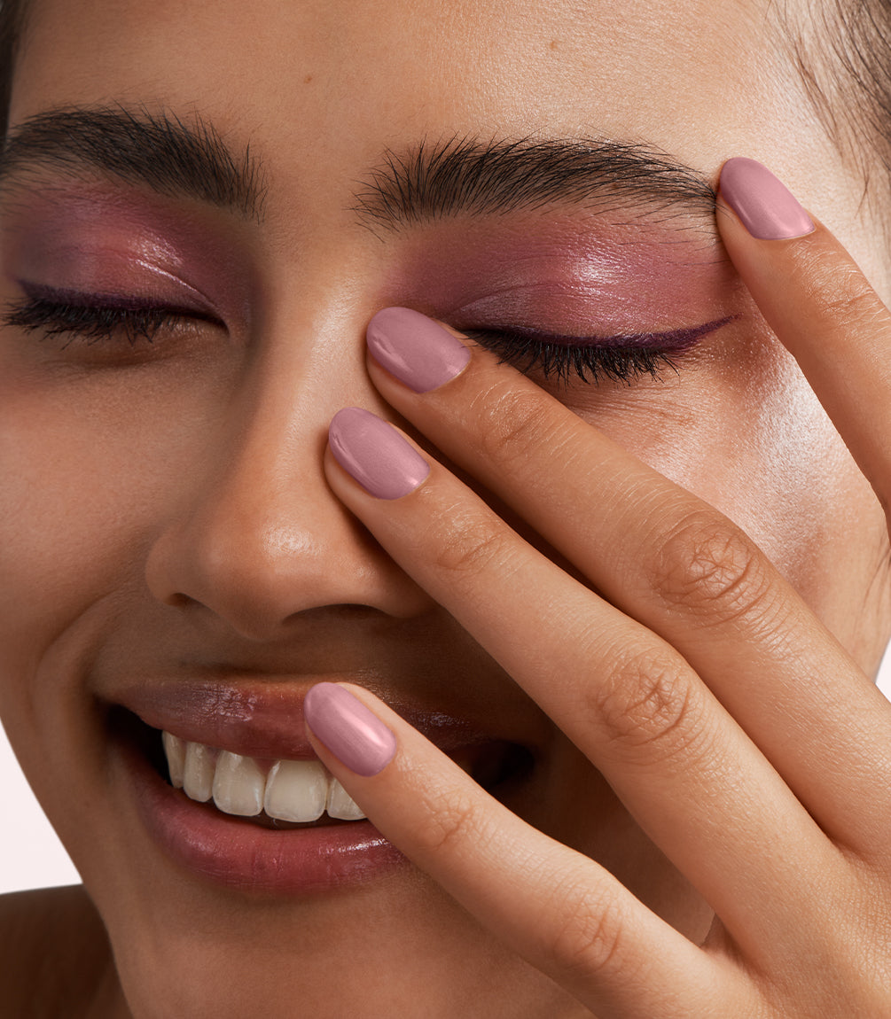 Close-up of a woman with Pink Gellac 454 Velvet Rose manicured nails near her face.