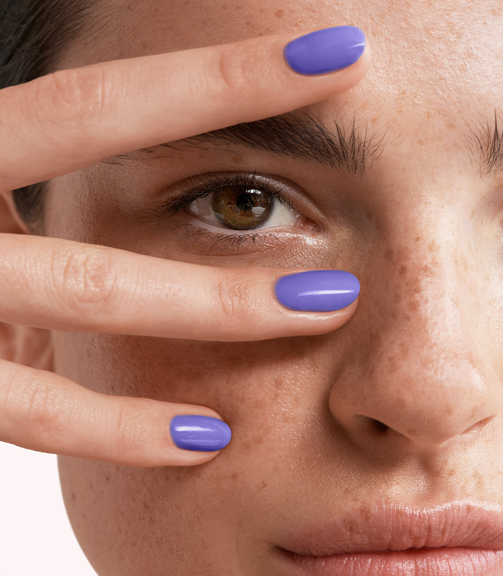 Close-up of a woman with Pink Gellac 455 Vivid Purple manicured nails near her face.