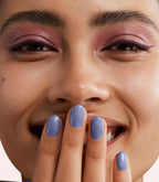 Close-up of a woman with Pink Gellac 456 Pearly Blue manicured nails near her face.