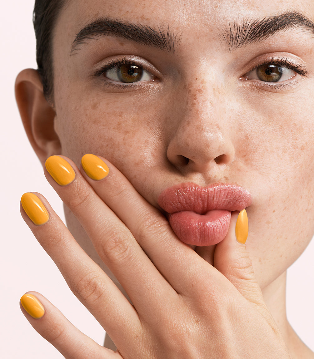 Close-up of a woman with Pink Gellac 459 Tangerine Whip manicured nails near her face.