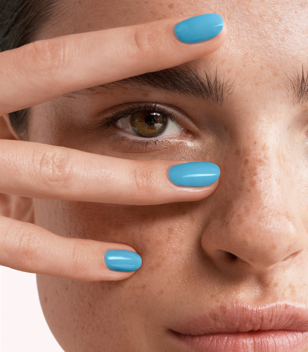 Close-up of a woman with Pink Gellac 460 Azure Sky manicured nails near her face.