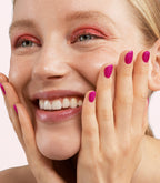 Close-up of a woman with Pink Gellac 463 Sparkling Magenta manicured nails near her face.