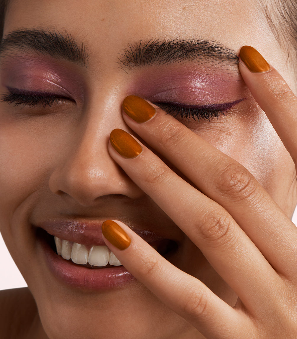 Close-up of a woman with Pink Gellac 468 Truffle Silk manicured nails near her face.