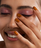 Close-up of a woman with Pink Gellac 468 Truffle Silk manicured nails near her face.