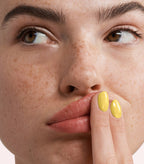 Close-up of a woman with Pink Gellac 287 Joyous Yellow manicured nails near her face.