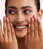 Close-up of a woman with Pink Gellac Jelly Coat Ballet Tint manicured nails near her face.