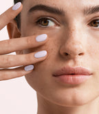 Close-up of a woman with Pink Gellac Rubber Base Cover Frozen Lilac manicured nails near her face.