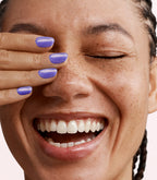 Close-up of a woman with Pink Gellac Jelly Coat Sapphire Drip manicured nails near her face.