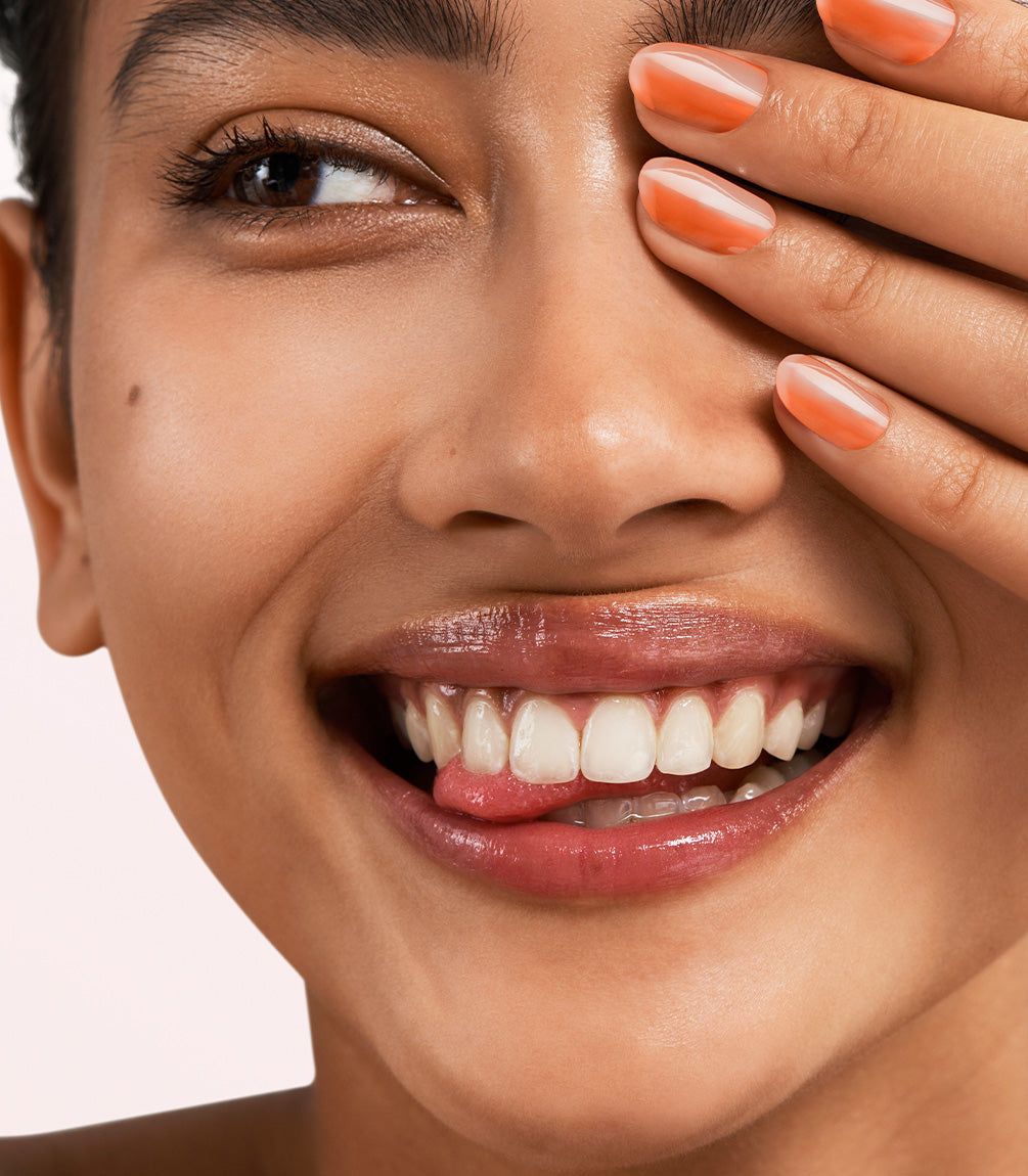Close-up of a woman with Pink Gellac Jelly Coat Solar Glaze manicured nails near her face.