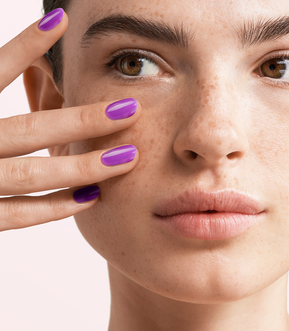 Close-up of a woman with Pink Gellac Jelly Coat Violet Sheen manicured nails near her face.