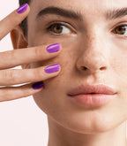 Close-up of a woman with Pink Gellac Jelly Coat Violet Sheen manicured nails near her face.