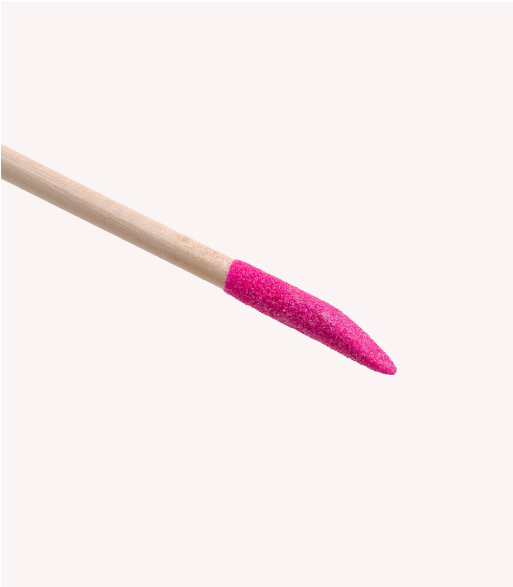 Wooden stick with a pink, sandpaper-like end.