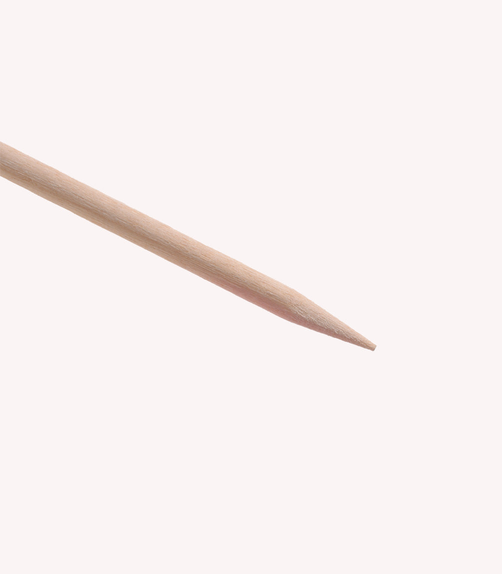 A wooden toothpick with a sharp point against a white background.