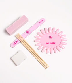 Nail care set with sanding buffer, nail file, wooden sticks, sponges and a pink nail colour sample.
